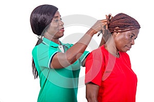 Woman in green t-shirt arranges hair of her comrade smiling