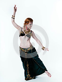 Woman in green tribal costume with top and skirt dancing on white background with copy space