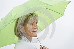 Woman With Green Umbrella Looking Away Against Clear Sky