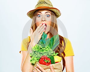 Woman with green vegan food. paper bag. surprise emotion.