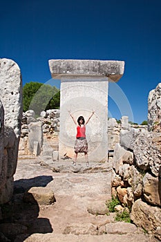 Woman greeting in prehistoric Taula in Minorca Island