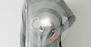 Woman in grey clothes suffering from indigestion pain, highlighted  visualisation of pancreas
