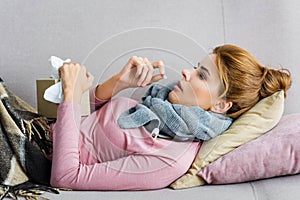 Woman with grey scarf taking pill