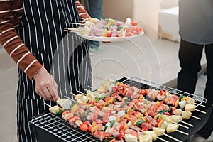 A woman grilling barbecue in dinner party. Food, people and family time concept