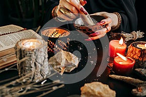 A woman grinds dried plants in a wooden mortar