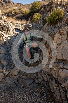 Woman Grins as She Downclimbs a Dry Fall