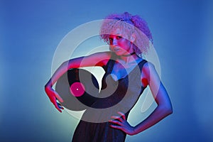 Woman with groovy hair holding an old vinyl with pink and blue