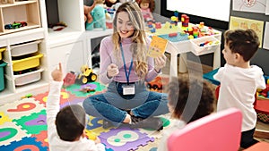 Woman and group of kids having vocabulary lesson with word cards at kindergarten