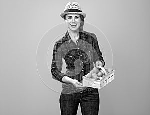 Woman grower isolated on yellow background basket with eggs