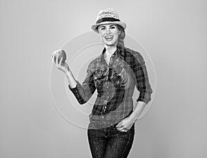 Woman grower isolated on yellow background showing an apple