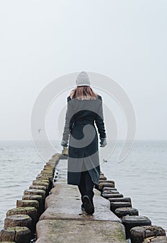 Woman on Groynes in the Baltic Sea during winter