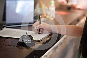 Woman guest at the reception of  hotel checking in