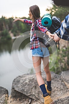 beautiful young woman with backpack guiding boyfriend