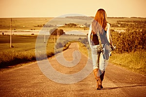 Woman with guitar at freeway