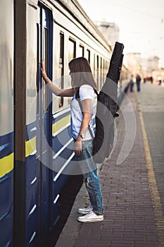 Woman with guitar at the railway station