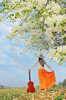 Woman and guitar standing and flower Cloud sky