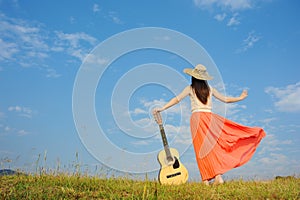 Woman and guitar standing on guitar with Cloud sky