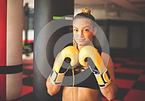 Woman in gym with boxers gloves