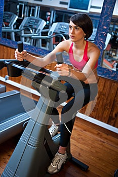 Woman in gym on bycicle photo