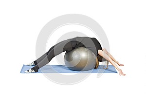 Woman in a gym clas on mats doing Pilates exercise with ball pilates. Stretching.