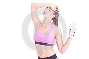 Woman at gym holding thermometer like summer heat