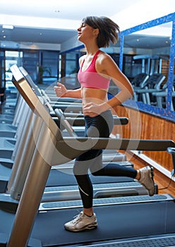 Woman in gym running on track