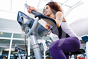 Woman in gym spinning on fitness bike