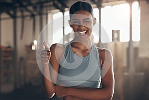 Woman in gym, thumbs up with wink in portrait, like fitness with emoji and health goals with sport and mockup space