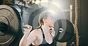 Woman at gym, weight lifting and barbell for muscle building endurance, strong body and balance power in fitness