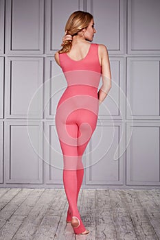 Woman gymnast athlete beautiful blonde dressed in a special costume for fitness yoga sport tight-fitting clothing made of nylon