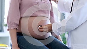 Woman gynaecologist checking the heartbeat baby of her pregnant patient in the clinic.