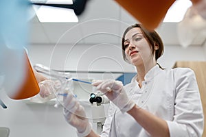 Woman gynecologist taking sample of biomaterial from patient urogenital tract photo