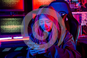 Woman hacker. Asian woman wearing hood working at computer and mobile phone