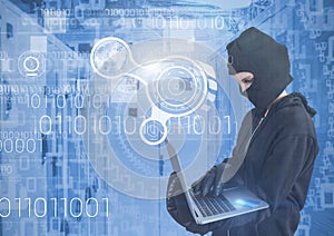 Woman hacker with hood using a laptop in data center