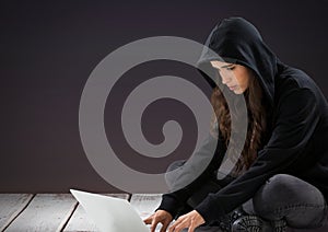 Woman hacker using a laptop in front of purple background