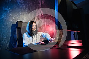 Woman hacker wearing an hood in front of computer screen