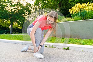 Woman had an accident with her ankle during sports and holds it tight