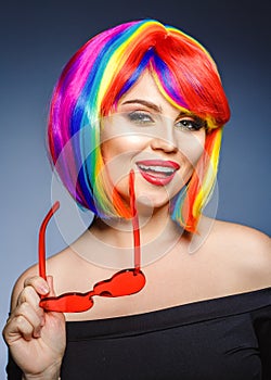 Woman hair as color splash. Rainbow up do short haircut. Beautiful young girl model with glowing healthy skin.