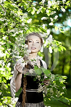 Woman with a hair braid in a blossoming park.