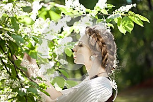 Woman with a hair braid in a blossoming park.