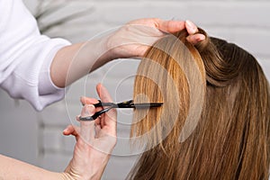 Woman hair care. Hairdresser making hairstyle to young girl in beauty salon.