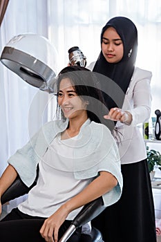 Woman hair dryer at salon