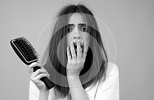 Woman with hair loss problem. Portrait of Young girl with a bald. Head shot of a nervous girl with a hairbrush.