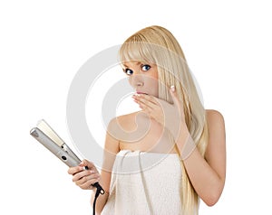 Woman with hair straighteners looking surprised