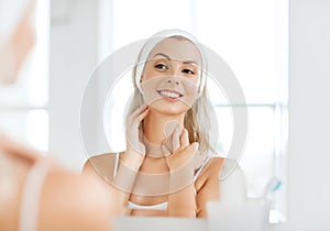 Woman in hairband touching her face at bathroom