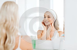 Woman in hairband touching her face at bathroom