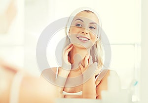 Woman in hairband touching her face at bathroom