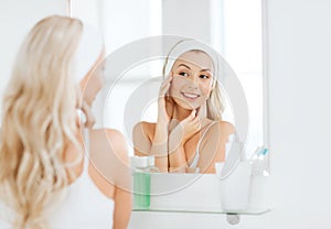 Woman in hairband touching her face at bathroom