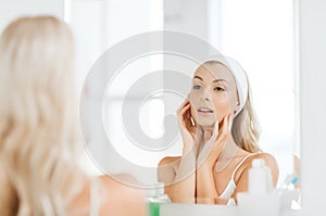 Woman in hairband touching her face at bathroom photo