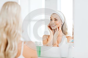 Woman in hairband touching her face at bathroom photo